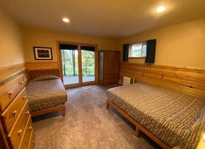 Downstairs bedroom with a queen, twin, and patio doors to the basement patio.