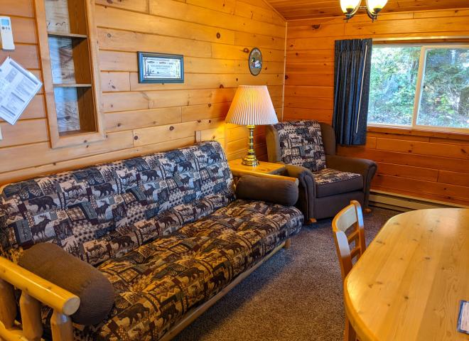 Living area with a futon, chair, and kitchen table.