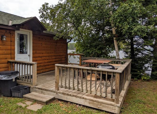 Sunbeam's entrance with deck, picnic table, and charcoal grill.