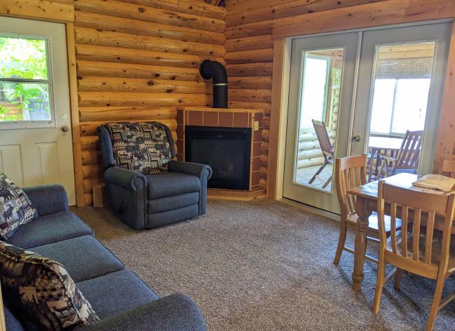 Living area with couch, recliner, kitchen table, gas fireplace, and access to the three season porch.