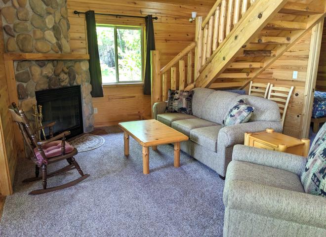 Living room with couch, recliner, and wood burning fireplace.