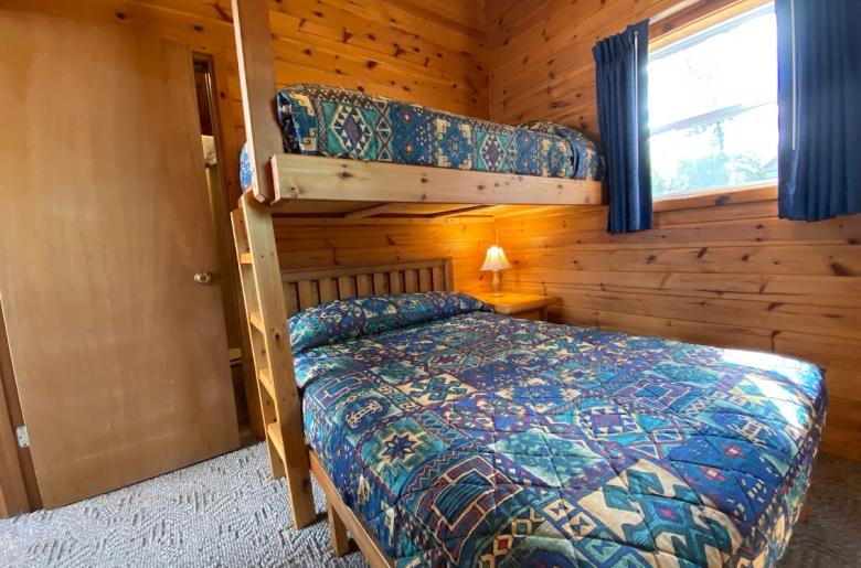 Bedroom with a full size bed, with a twin lofted above it, and an ensuite bathroom.