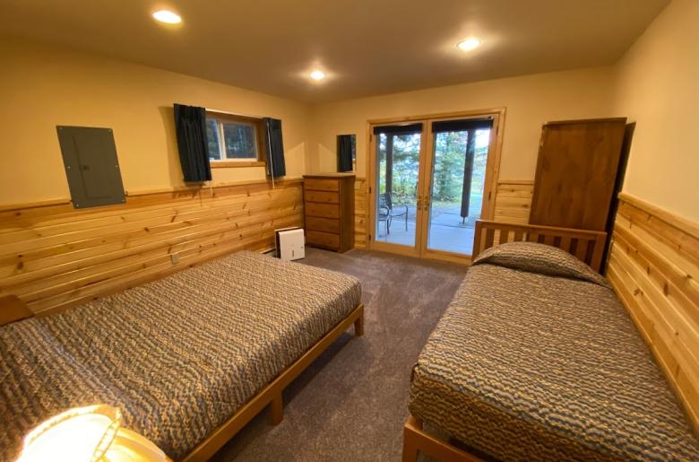 Downstairs bedroom with a queen, twin, and patio doors to the basement patio.