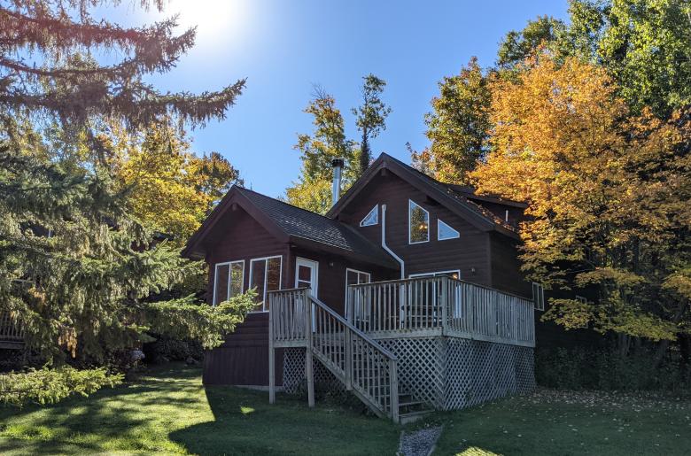 Exterior of two story Chickadee cabin, with the sun rising.