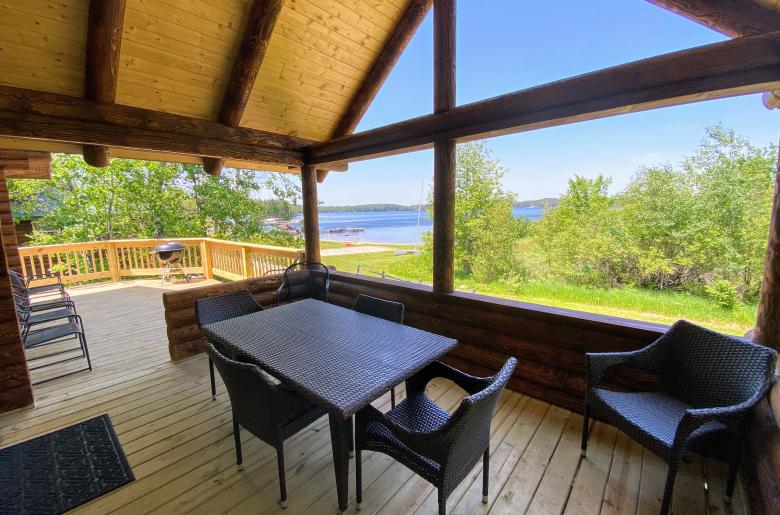 Covered porch area with seating and views of the beach.