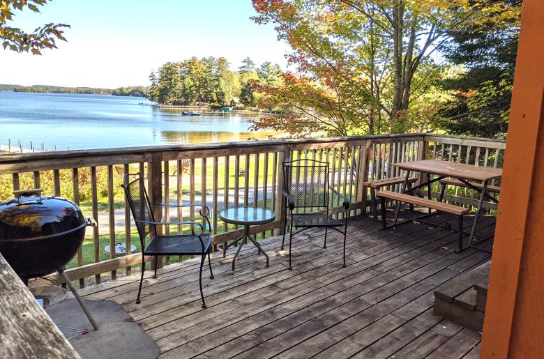Deck area with a picnic table, charcoal grill, and overlooks the beach.