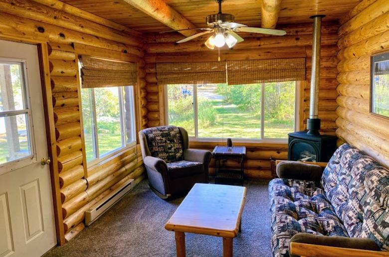 Living room with futon, recliner, gas fireplace, and views of your private yard next to the lake.