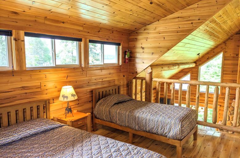 Loft bedroom with a queen and twin bed, as well as an ensuite bathroom.