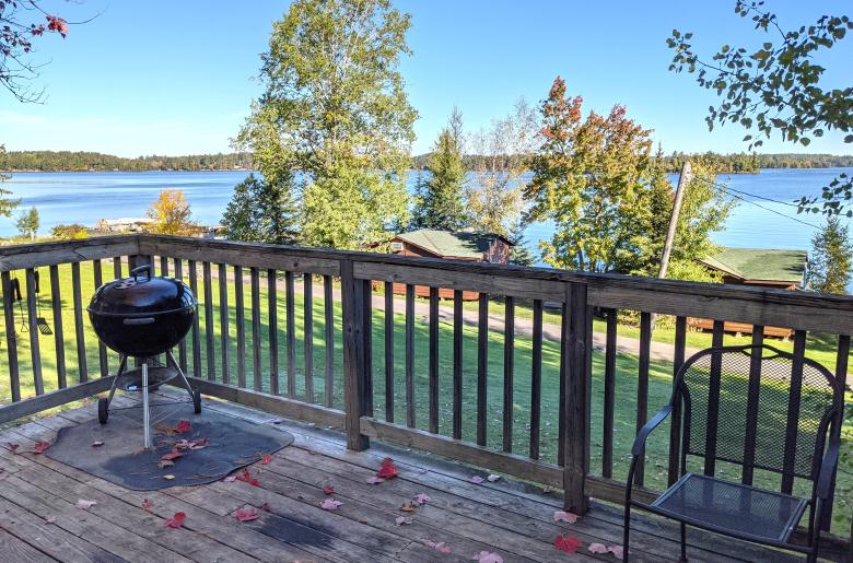 Deck area overlooking the lake with a charcoal grill.
