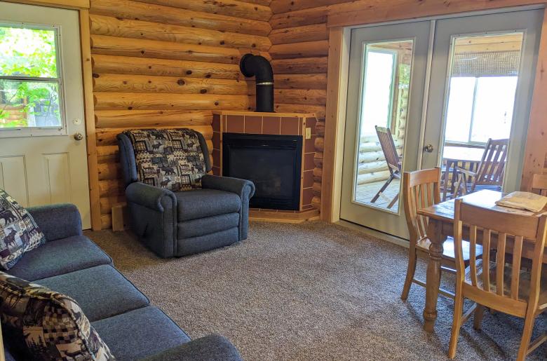 Living area with couch, recliner, kitchen table, gas fireplace, and access to the three season porch.