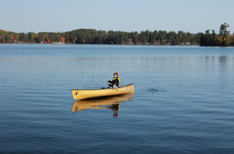 Boy solo-paddling a canoe on Lake Vermilion
