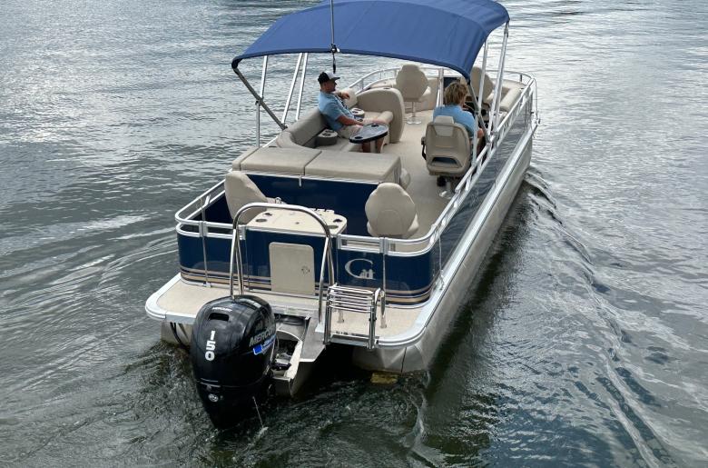 Fishing triple-toon with the canopy up heading out for a trip.