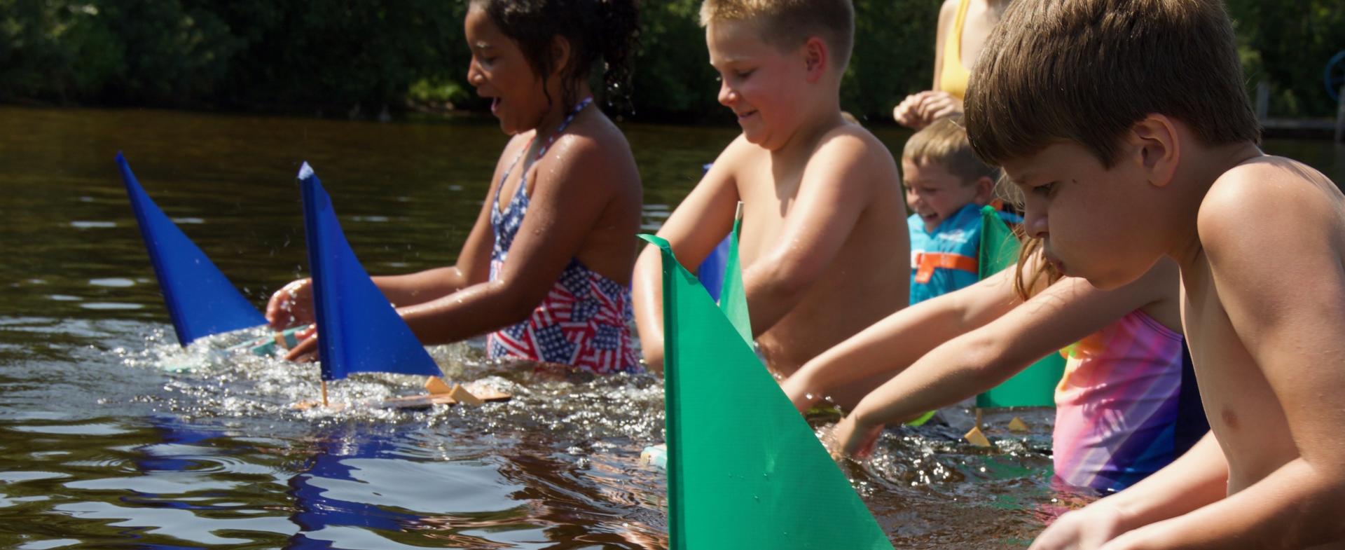 Children race their sailboats during Kids Program at Pehrson Lodge