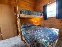 Bedroom with a full size bed, with a twin lofted above it, and an ensuite bathroom.