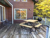 Deck area with picnic table, charcoal grill, and views of the lake.