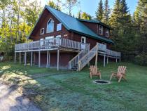 Exterior of large Sandpiper cabin with firepit.