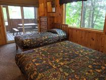 Main floor bedroom with queen, twin, and patio door to the screen porch.