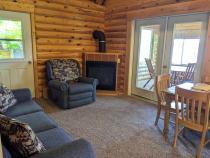 Living area with couch, recliner, kitchen table, gas fireplace, and access to the three season porch.
