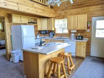Kitchen with refrigerator, stove, dishwasher, and island seating.